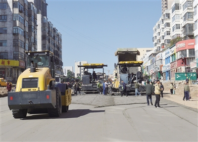 图为摊铺机正在对道路西段的路面摊铺二灰层材料。戎禹仁摄